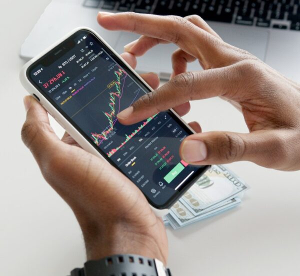 Hands scrolling through financial market data on a mobile phone
