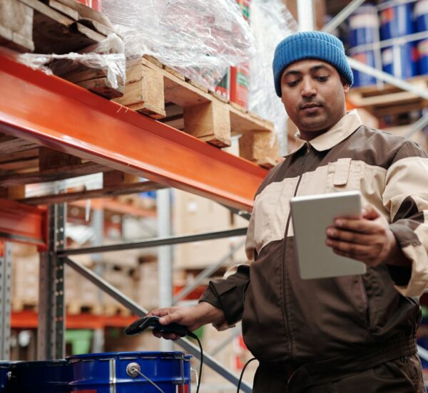 Man taking stock on an ipad in a warehouse