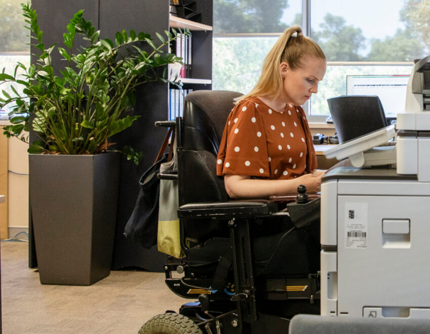 Woman in a wheel chair working in an office.