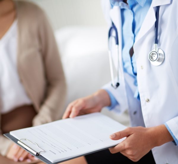 Doctor holding a notepad while talking to patient