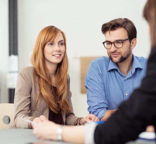 Young couple consulting a woman in an office