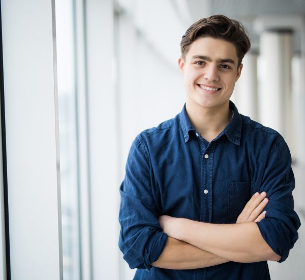 Man in a blue shirt arms folded smiling at the camera