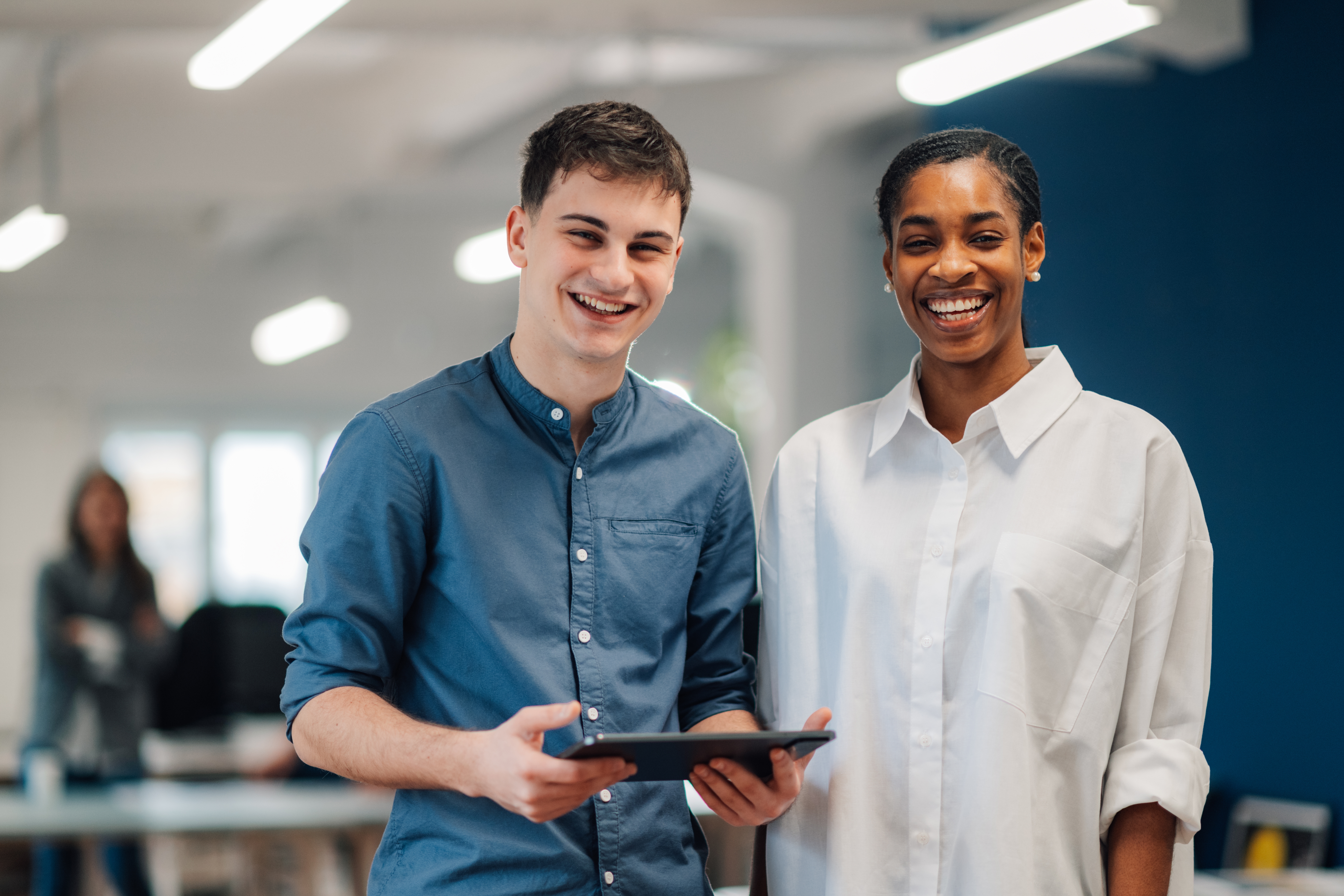 Young man and woman smiling in an office.