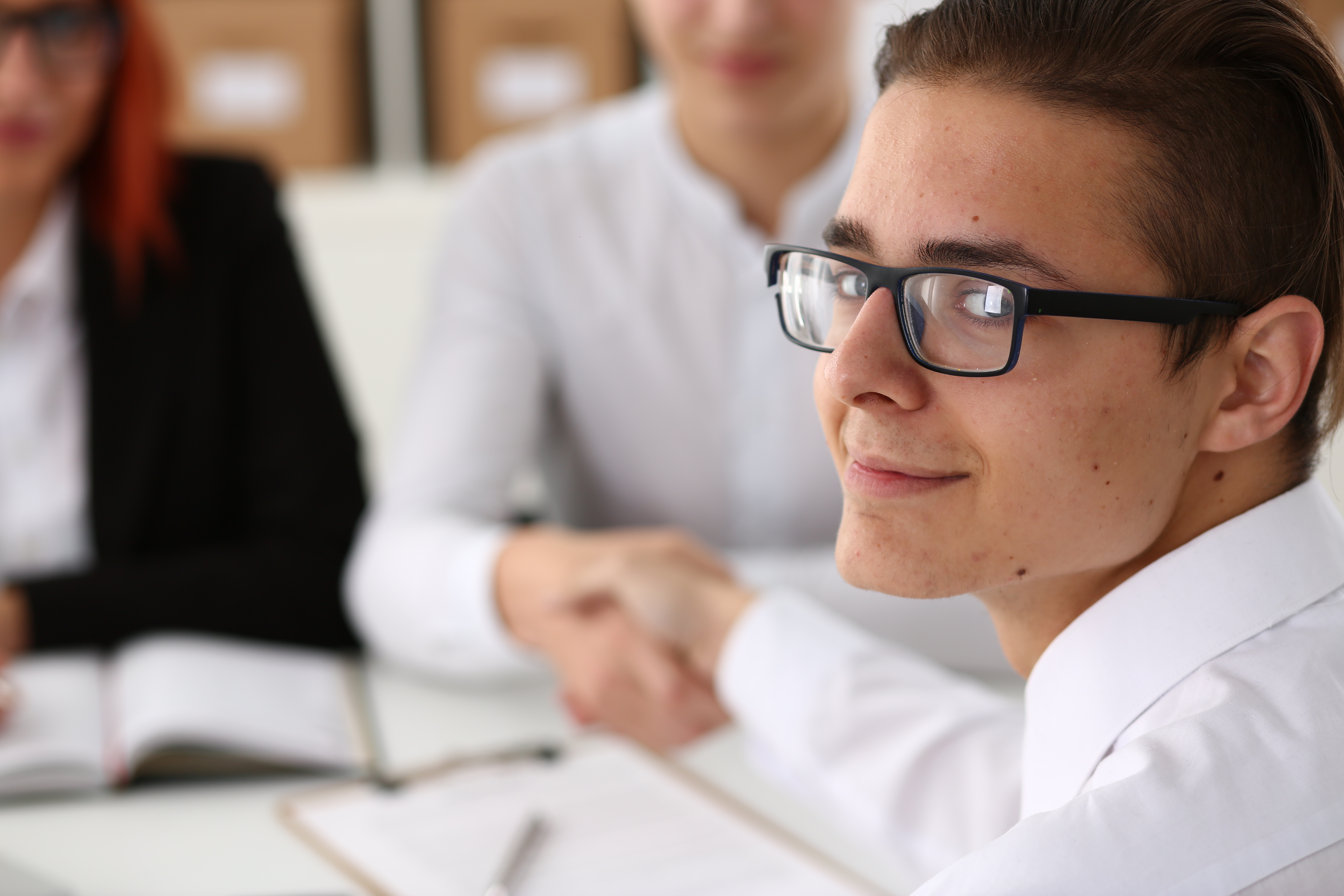Smiling young man shaking hands with an interviewer.